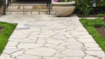 Flagstone landscape stones installed on compacted gravel base creating durable garden pathway