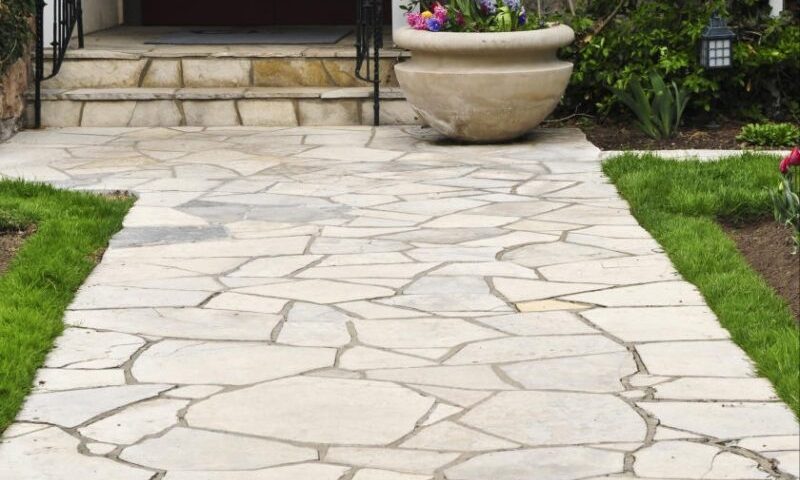 Flagstone landscape stones installed on compacted gravel base creating durable garden pathway