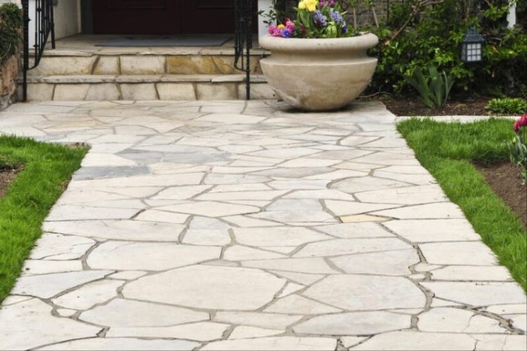 Flagstone landscape stones installed on compacted gravel base creating durable garden pathway
